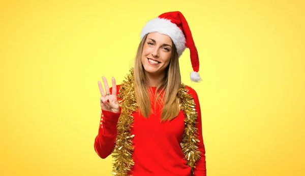 金髪の女性ドレスアップ クリスマス休暇の黄色背景に指で幸せでカウント — ストック写真