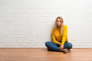 Üzgün ve depresyonda ifade ile katta oturan genç kız. Ciddi jest