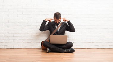Her iki kulak elleriyle branda oturup onun laptop ile işadamı