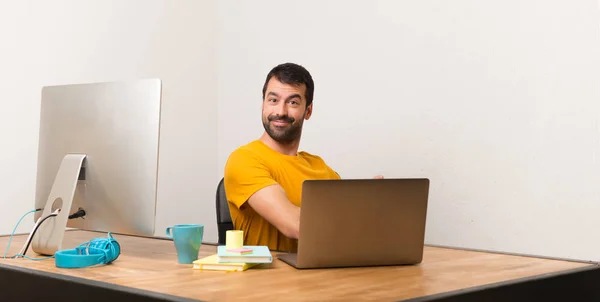 Чоловік Працює Ноутбуком Офісі Вказуючи Назад Представляючи Продукт — стокове фото