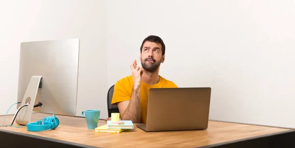 Чоловік Працює Ноутбуком Офісі Пальцями Перетинаючи Бажаючи Кращого — стокове фото