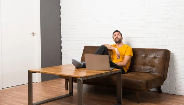 Man Met Zijn Laptop Een Kamer Opzoeken Met Ernstige Gezicht — Stockfoto