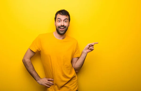 Muž Izolované Zářivé Žluté Barvy Ukazující Prstem Stranu Prezentace Produktu — Stock fotografie