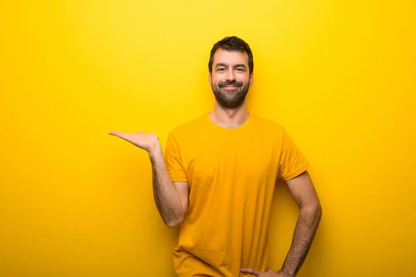 Muž Izolované Zářivé Žluté Barvy Drží Imaginární Copyspace Dlani Vložit — Stock fotografie