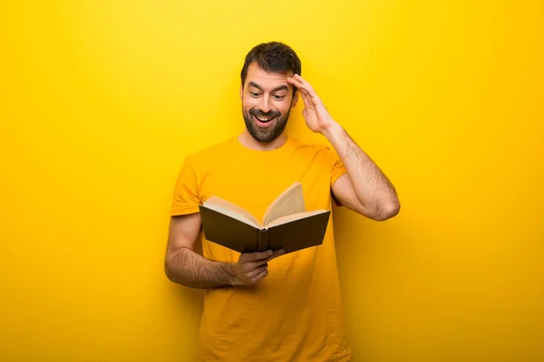 Mann Auf Vereinzelten Lebendigen Gelben Farbe Hält Ein Buch Und — Stockfoto