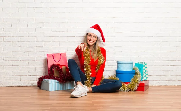 Mädchen Mit Weihnachtsmütze Und Vielen Geschenken Zum Weihnachtsfest Zeigt Mit — Stockfoto
