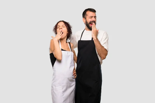 Dva Kuchaři Zíval Pokrývající Ústa Rukou Ospalý Výraz Šedém Pozadí — Stock fotografie
