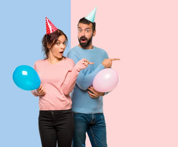 Couple Avec Des Ballons Des Chapeaux Anniversaire Pointant Doigt Sur — Photo