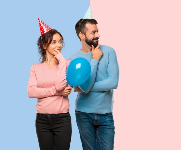Couple Avec Des Ballons Des Chapeaux Anniversaire Regardant Sur Côté — Photo