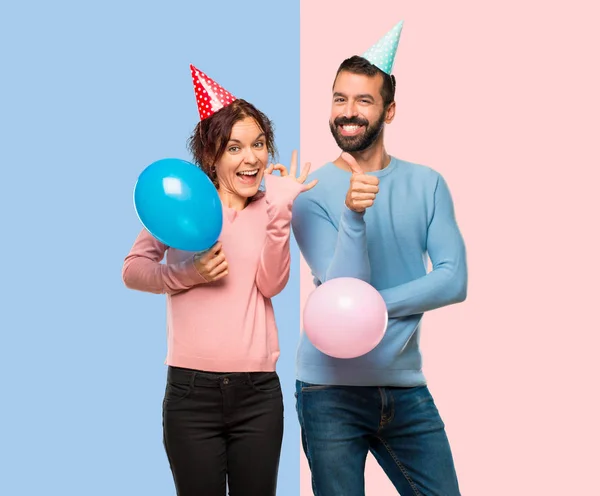 Pareja Con Globos Sombreros Cumpleaños Mostrando Signo Dando Gesto Pulgar —  Fotos de Stock