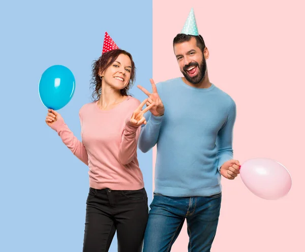 Couple Avec Des Ballons Des Chapeaux Anniversaire Souriant Montrant Signe — Photo