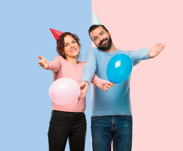 Casal Com Balões Chapéus Aniversário Apresentando Convidando Para Vir Feliz — Fotografia de Stock