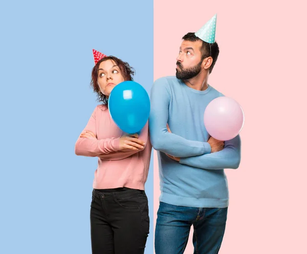 Pareja Con Globos Sombreros Cumpleaños Haciendo Gesto Sin Importancia Levantar —  Fotos de Stock