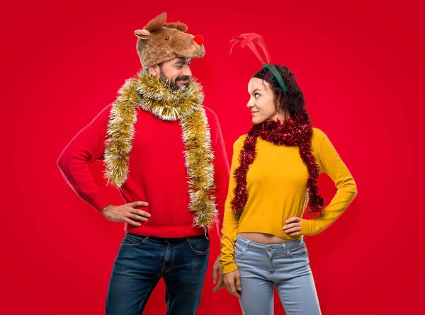 Pár Převlečený Vánoční Svátky Pózuje Rukama Kyčle Usmívá Izolovaná Červeném — Stock fotografie