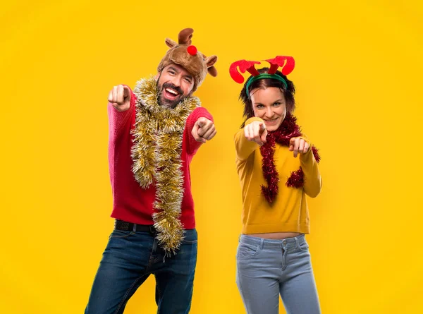 Paar Verkleed Voor Kerst Vakantie Punten Vinger Terwijl Glimlachend Gele — Stockfoto