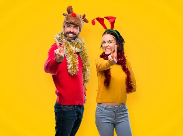Paar Verkleidet Für Die Weihnachtsfeiertage Lächelnd Und Mit Siegeszeichen Auf — Stockfoto