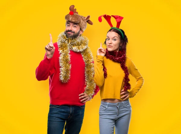 Paar Verkleidet Für Die Weihnachtsfeiertage Zeigt Und Hebt Einen Finger — Stockfoto