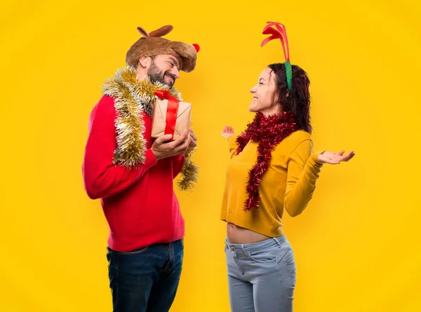 Casal Vestido Para Feriados Natal Segurando Presente Fundo Amarelo — Fotografia de Stock