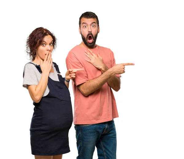 Couple Pregnant Woman Pointing Finger Side Surprised Face Isolated White — Stock Photo, Image