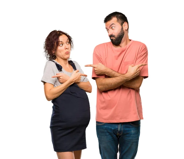 疑問を持つ根を指している妊娠中の女性とカップルします 分離の白い背景の上の未定の人 — ストック写真