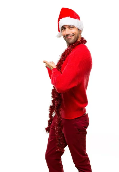 Человек Красной Одежде Празднует Рождественские Праздники Указывая Назад Представляя Продукт — стоковое фото