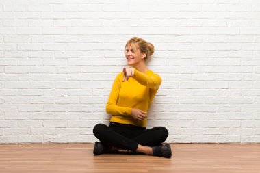 Katta oturan genç kız seni kendinden emin bir ifade ile parmak işaret