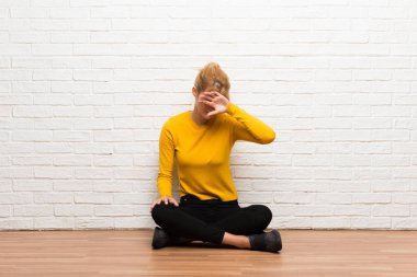 Yorgun ve hasta ifade ile katta oturan genç kız