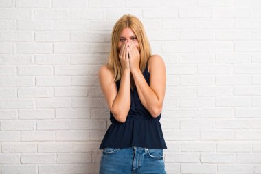 Sarışın kadın çok ağız beyaz tuğla duvar arka plan üzerinde kapsayan süre gülümseyen