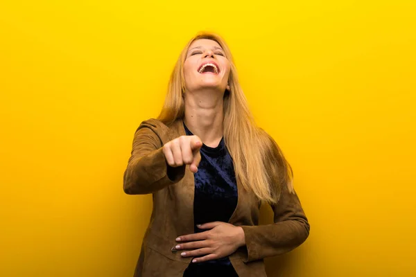 Blond Dívka Zářivé Žluté Pozadí Ukazuje Prstem Někoho Hodně Smíchu — Stock fotografie