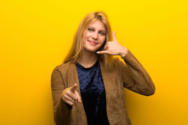 Menina Loira Fundo Amarelo Vibrante Fazendo Gesto Telefone Apontando Frente — Fotografia de Stock