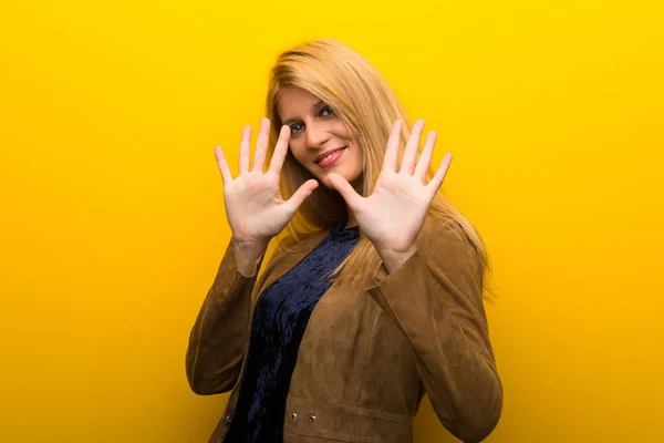 Блондинка Яскраво Жовтому Тлі Підраховує Десять Пальцями — стокове фото