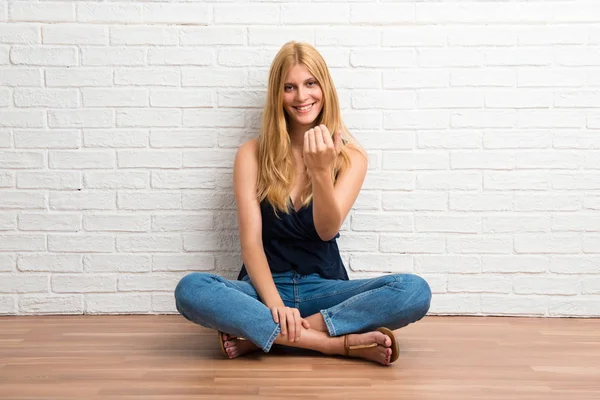 Blond Meisje Zittend Vloer Presenteren Uitnodigen Komen Witte Bakstenen Muur — Stockfoto