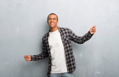 Kareli gömlek ile genç Afro-Amerikan adam zevk müzik bir partide dans