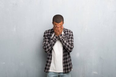 Yorgun ve hasta ifade ile damalı gömlek ile genç Afro-Amerikan adam