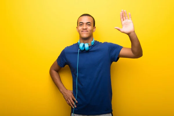 Uomo Afroamericano Con Shirt Blu Sfondo Giallo Che Saluta Con — Foto Stock