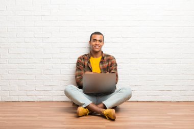Afrika kökenli Amerikalı adam ön konumda geçti silah tutmak onun laptop ile katta oturan
