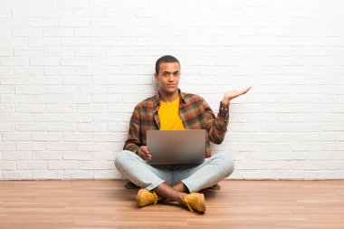 Afrika kökenli Amerikalı adam boşaltmak hayali avuç içinde tutarak onun laptop ile katta oturan bir reklam eklemek için