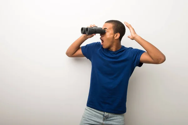 Giovane Uomo Afroamericano Parete Bianca Guardando Lontananza Con Binocolo — Foto Stock