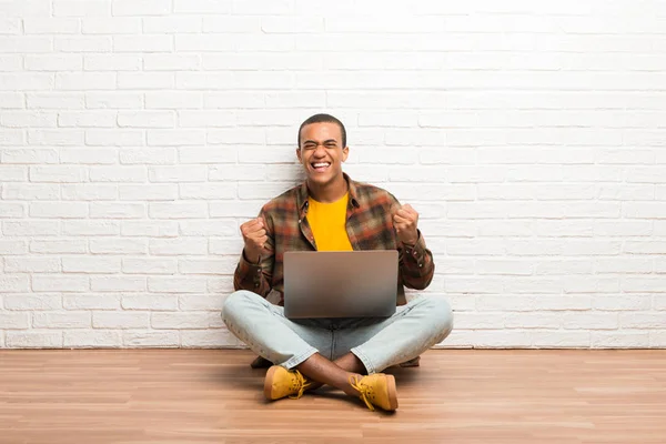 Africano Americano Sentado Chão Com Seu Laptop Comemorando Uma Vitória — Fotografia de Stock