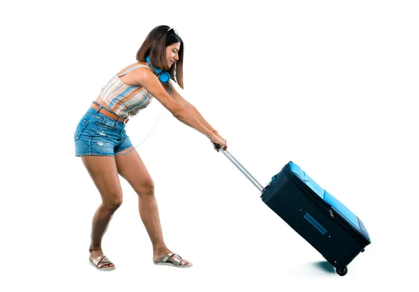 分離の白い背景の上にたくさん重さ旅行とスーツケースを引いて女の子の全身 — ストック写真
