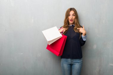 Kız alışveriş torbaları ile sürpriz yüz ifadesi ile