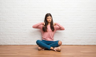 Her iki el ile Oda gösteren pratik bir yerde oturarak genç kız