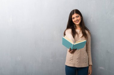 Kazak üzerine bir kitap ve birine vererek bir duvar ile genç kız
