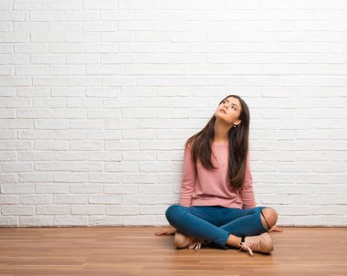 Ciddi bir yüz ile ararken bir odada katta oturan genç kız