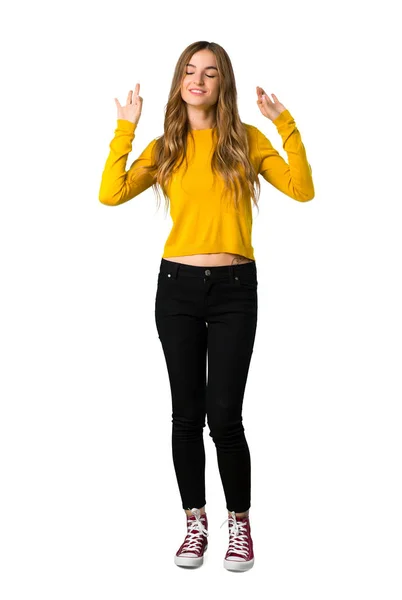 禅ポーズ分離の白い背景の上に黄色のセーターを持つ少女のフルレングス ショット — ストック写真