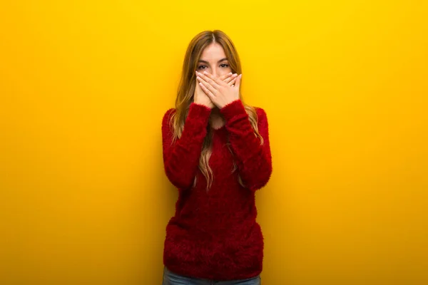 不適切な何かを言うための手で口を覆っている鮮やかな黄色の背景に若い女の子 — ストック写真