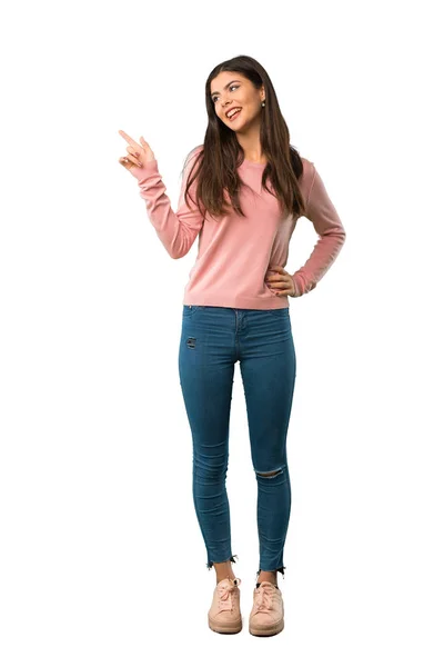 一个穿着粉色衬衫的少女的全长照片 她的手指指向一边 并呈现一个产品 — 图库照片