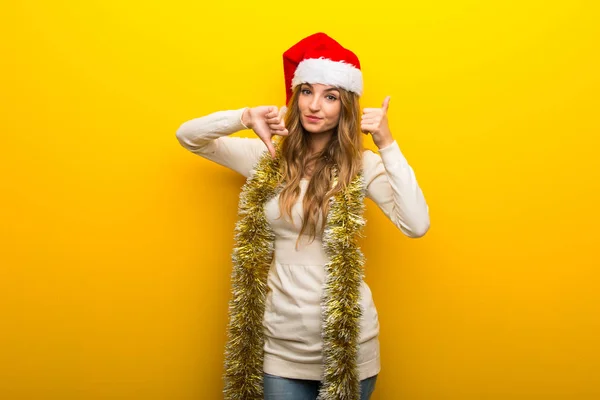 Menina Comemorando Feriados Natal Fundo Amarelo Fazendo Bom Mau Sinal — Fotografia de Stock