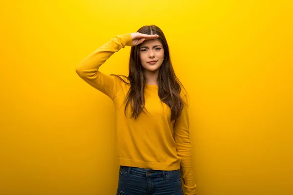 Nastolatek Dziewczyna Żywe Żółtym Tle Patrząc Daleko Ręką Szukać Coś — Zdjęcie stockowe
