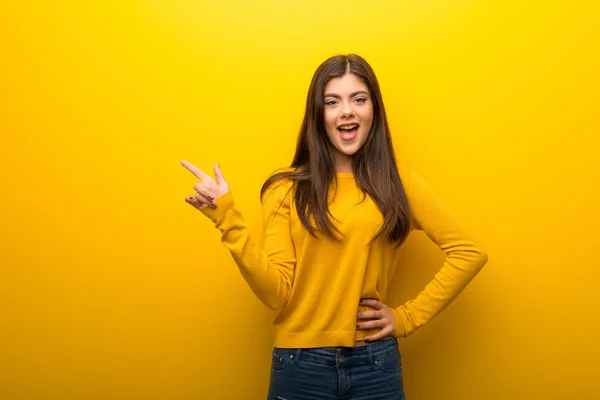 Teenager Mädchen Auf Leuchtend Gelbem Hintergrund Zeigt Mit Dem Finger — Stockfoto
